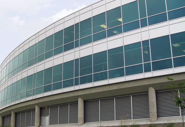 The image depicts a large commercial building with Mapes paneling.