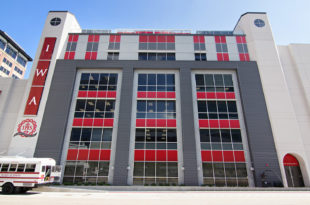 This image depicts a large, multi-story school building with red and gray panels from Mapes.