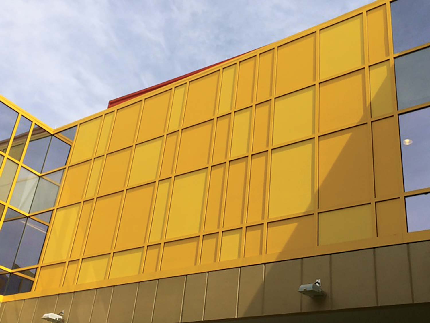 This image depicts a school building with yellow Mapes panels integrated into the design.