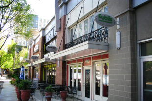 A row of storefronts with Mapes canopies on a quaint street.