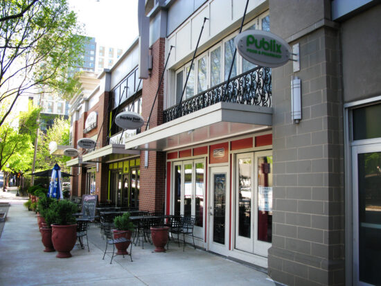 A row of storefronts with Mapes canopies on a quaint street.